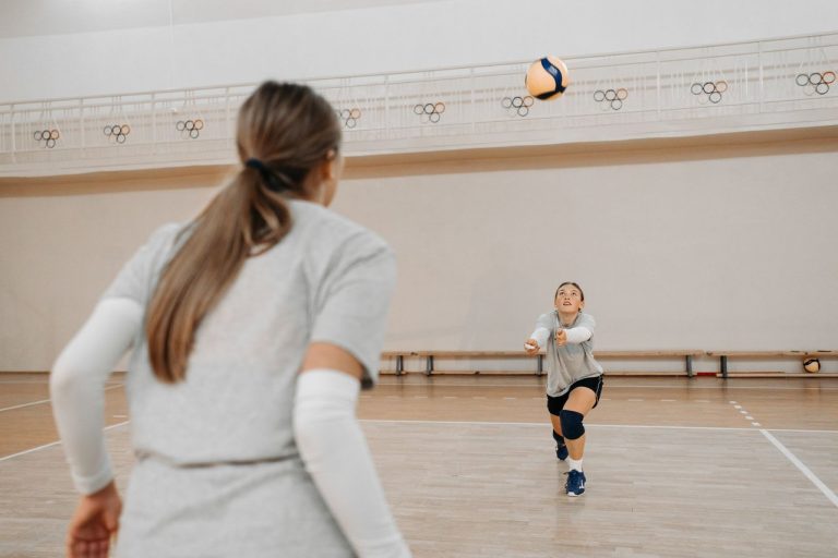 O vôlei que se mede em tempo real: como a tecnologia reorganiza a Superliga Jogadoras treinam vôlei em uma quadra coberta, praticando controle de bola e trabalho em equipe.